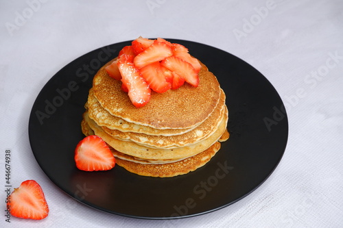 Pancakes with strawberries on a blurred background. Food photography.
