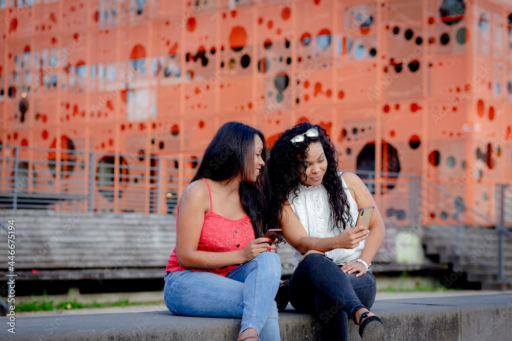 couple of young women with smart phone in lyon france couple of young women with smart phone in lyon france