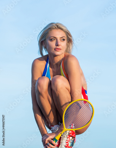 sexy woman with fit body in swimsuit hold badminton racquet on sky background, summer vacation. © be free