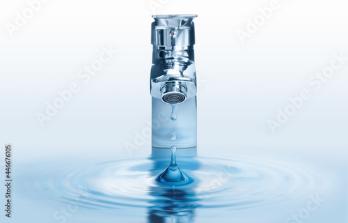 Water dripping from tap with splash on light background