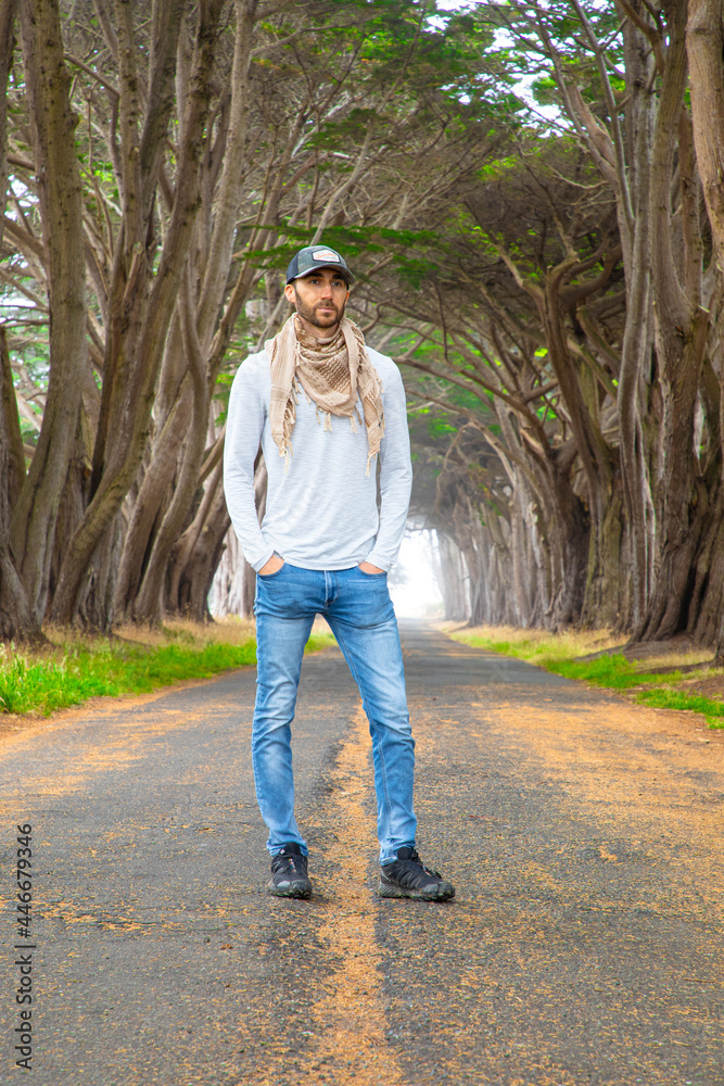 Man modeling in roadway with tree tunnel