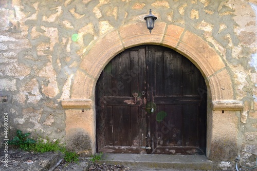 an old large wooden front door to the yard of an old house