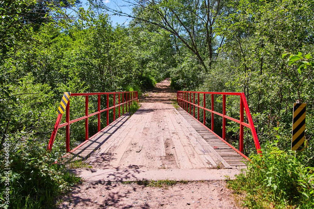 Old wood road bridge with red railing
