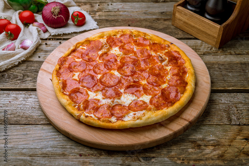 Pepperoni pizza on old wooden table