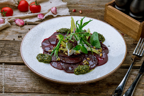 beetroot carpaccio with sause pesto on plate on old wooden table