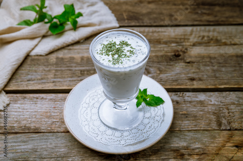 ayran in a glass on old wooden table photo