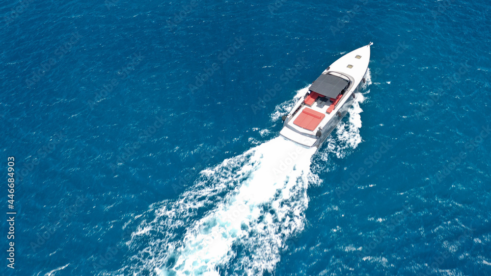 Obraz premium Aerial drone photo of small luxury speed boat cruising in deep blue waters of Mykonos island, Cyclades, Greece