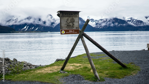 Seward to Nome milestone board on wooden planks on a coast photo