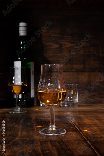 Glasses of strong scotch single malt whisky served on dark wooden table in old pub