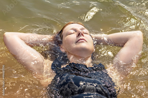 Portrait of a young woman close-up in the water. Swimming in the lake