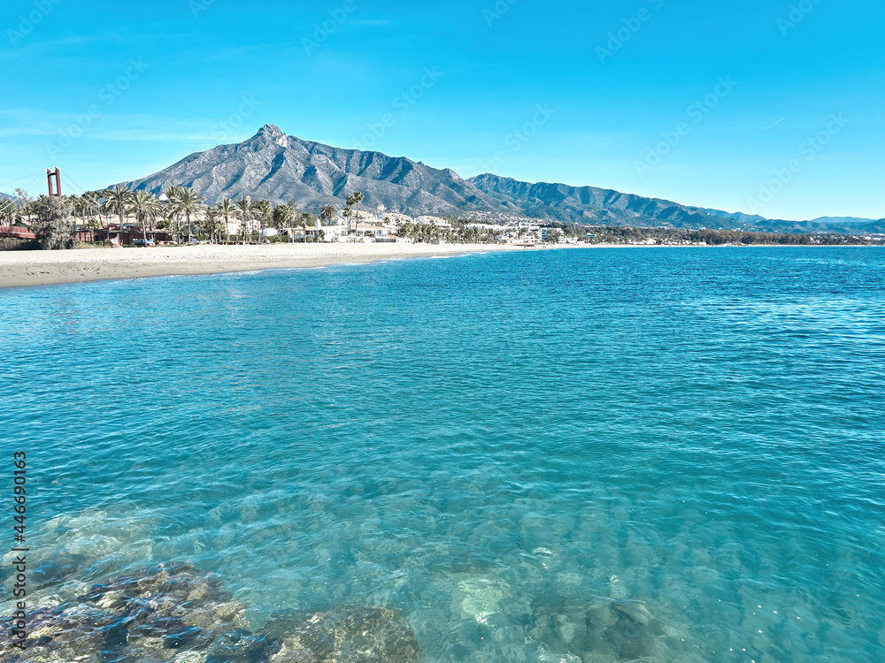 Marbella beach with blue sky and the shell behind. La Concha is the