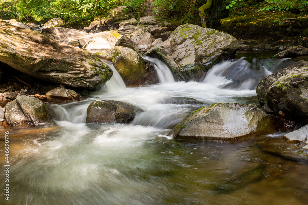 Long exposure of a waterfall on the East Lyn river at Watersmeet In Exmoor National Park Long exposure of a waterfall on the East Lyn river at Watersmeet In Exmoor National Park