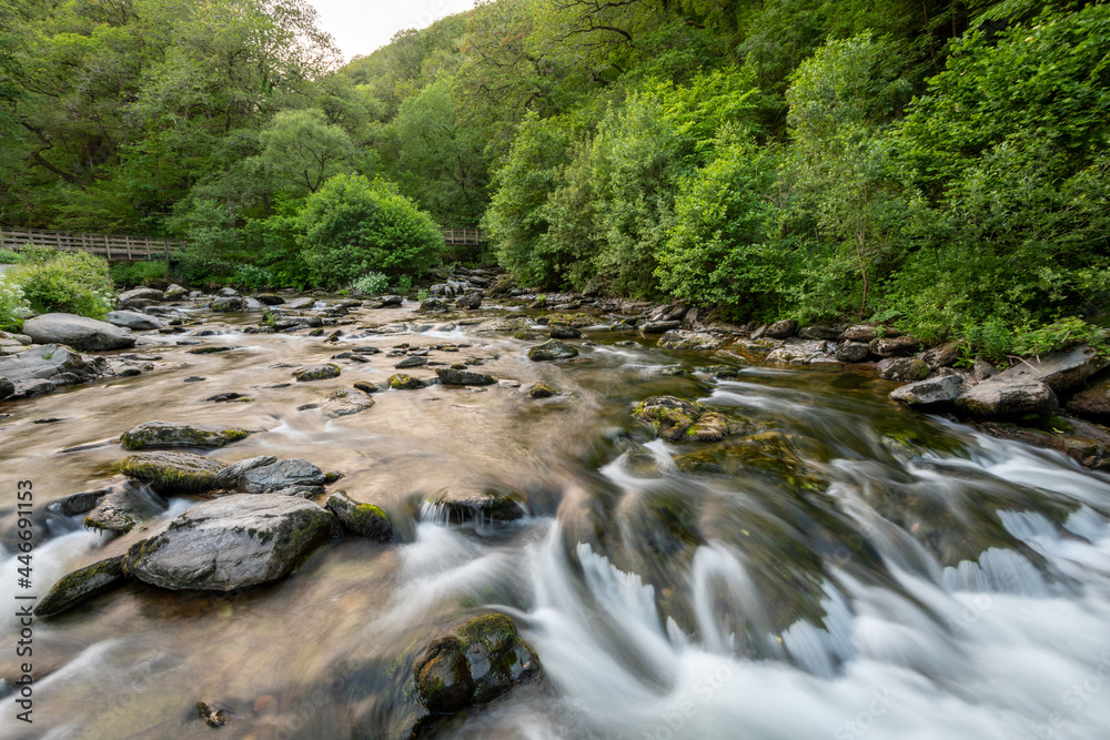 Long exposure of a waterfall on the East Lyn river at Watersmeet In Exmoor National Park Long exposure of a waterfall on the East Lyn river at Watersmeet In Exmoor National Park