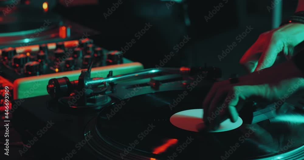 Deejay playing music, black vinyl record spinning on DJ turntable during party performance. Nightlife concept