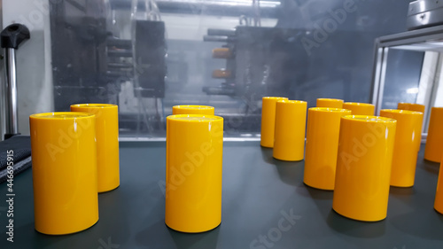 Yellow Plastic product bottle parts. made from plastic injection molding machine, in plastic factory industry.