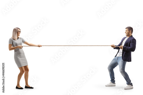 Obraz na plátne Full length profile shot of a young man and woman pulling a rope
