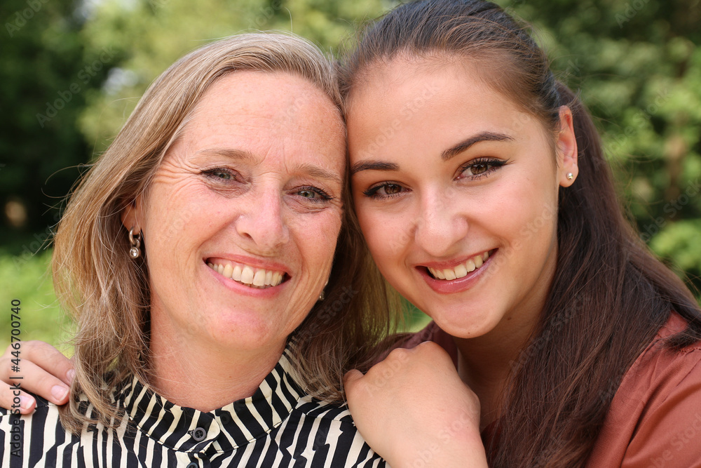 Mother and daughter being happy outside