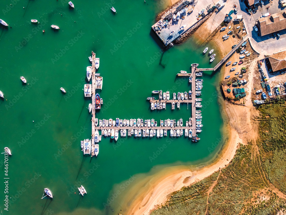 Aerial view of boats anchored at pier at Alvor city port in Ribeira de Odiaxere, Alvor, Algarve region, Portugal. Aerial view of boats anchored at pier at Alvor city port in Ribeira de Odiaxere, Alvor, Algarve region, Portugal.