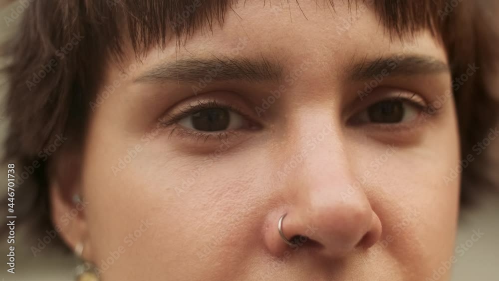 A beautiful dark haired girl wearing ring in her nose. A gorgeous young lady's fase close-up. Dark eyed female looking at camera. A serious or sad look of a woman with a short modern haircut. A beautiful dark haired girl wearing ring in her nose. A gorgeous young lady's fase close-up. Dark eyed female looking at camera. A serious or sad look of a woman with a short modern haircut.