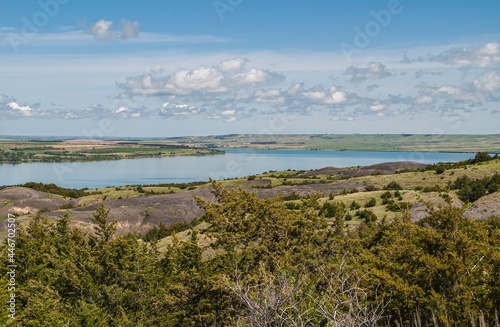 Chamberlain, SD, USA - June 2, 2008: Missouri River North of town. Landscape offers wide blue bend under blue cloudscape and surrounded by lots of green by meadows and tree foliage. photo