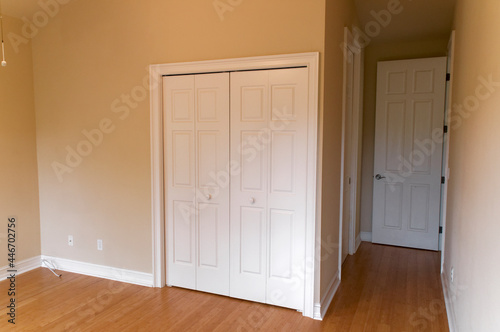 empty neutral colored room room with wood floors and many doors