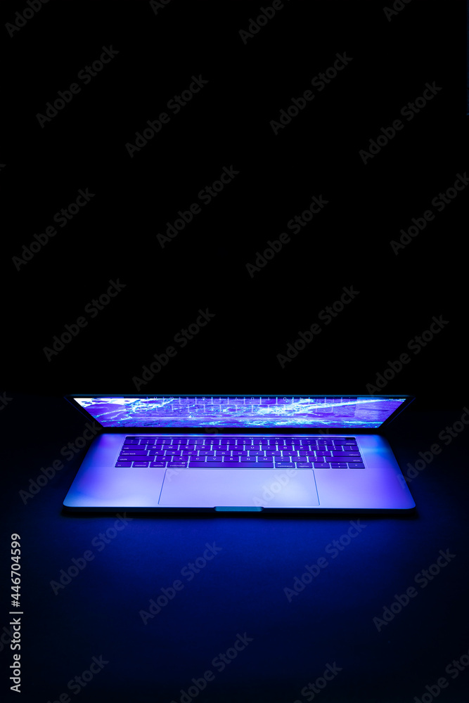 Isolated high tech open laptop with abstract vibrant color screen on a dark background. - obrazy, fototapety, plakaty 
