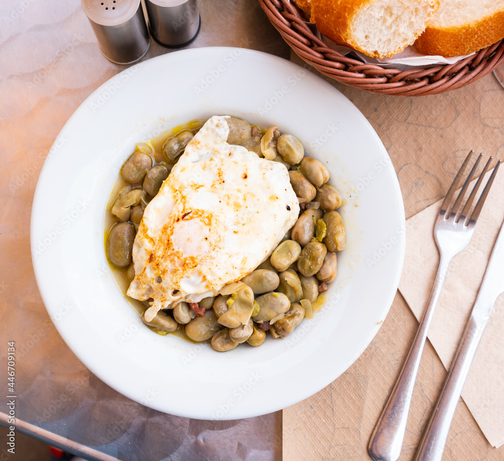 Broad beans with ham and fried egg closeup
