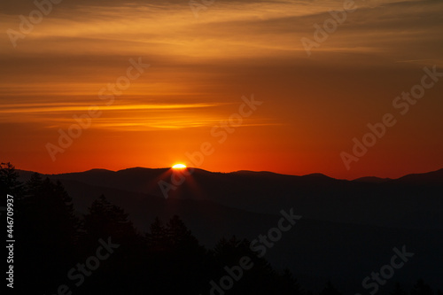 Warm orange Sunrises over silhouetted forest and mountain tops at New Foundland Gap in the Great Smoky Mountains photo