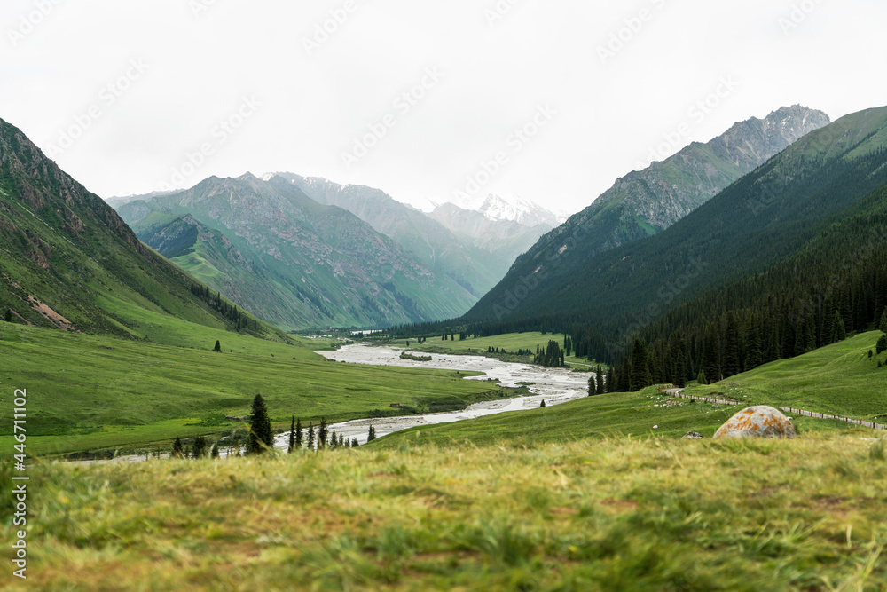 Fototapeta premium River and mountains with white clouds.