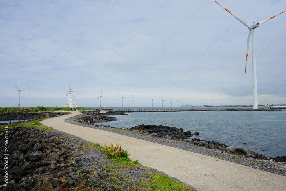 a beautiful seaside view with lighthouse and wind power plant