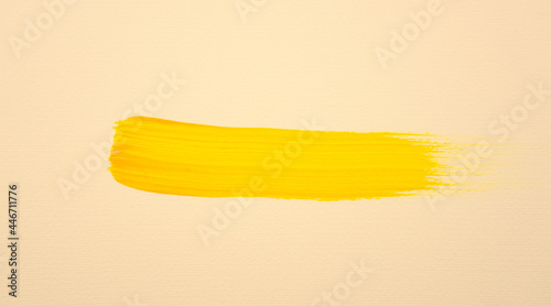 Handmade, hand drawn brush stroke bright yellow gold acrylic color on pastel earth tone background. Fluid art texture on canvas.