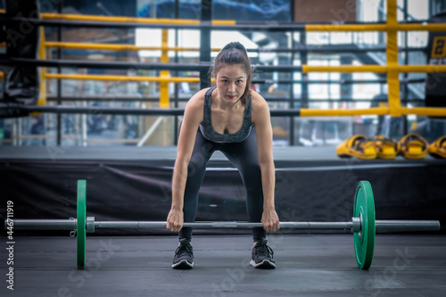 Sport woman doing exercises with dumbbell at gym ,she exercise for good healthy , bodybuilding and muscle.