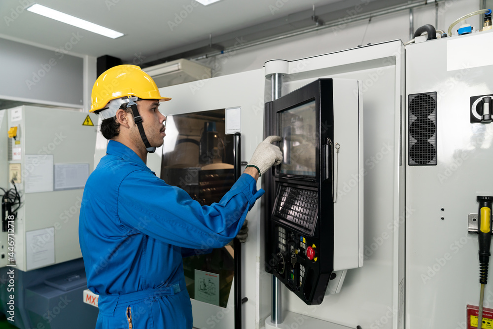 Asian technician engineer operating CNC machine in workshop. Asian technician engineer operating CNC machine in workshop.