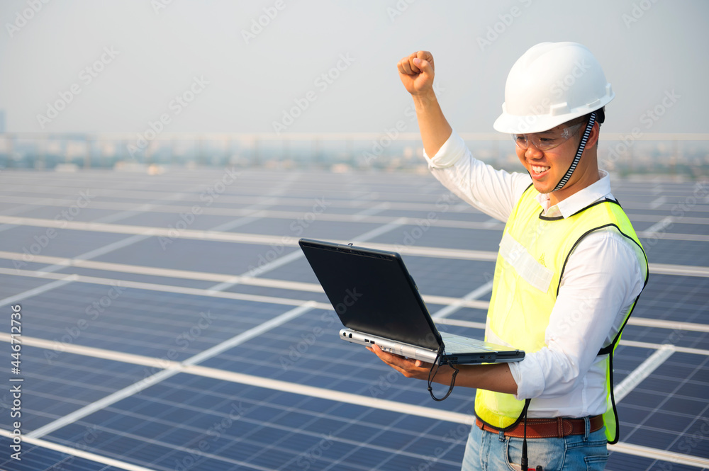 Engineer holding notebook sets the operation of the solar panel on the roof of the building to work at full efficiency.Using solar cells is energy saving. Renewable energy concepts. Engineer holding notebook sets the operation of the solar panel on the roof of the building to work at full efficiency.Using solar cells is energy saving. Renewable energy concepts.