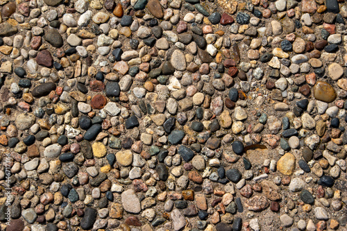 Top view close-up texture background of a vintage exposed aggregate stone patio surface in bright natural sunlight
 photo