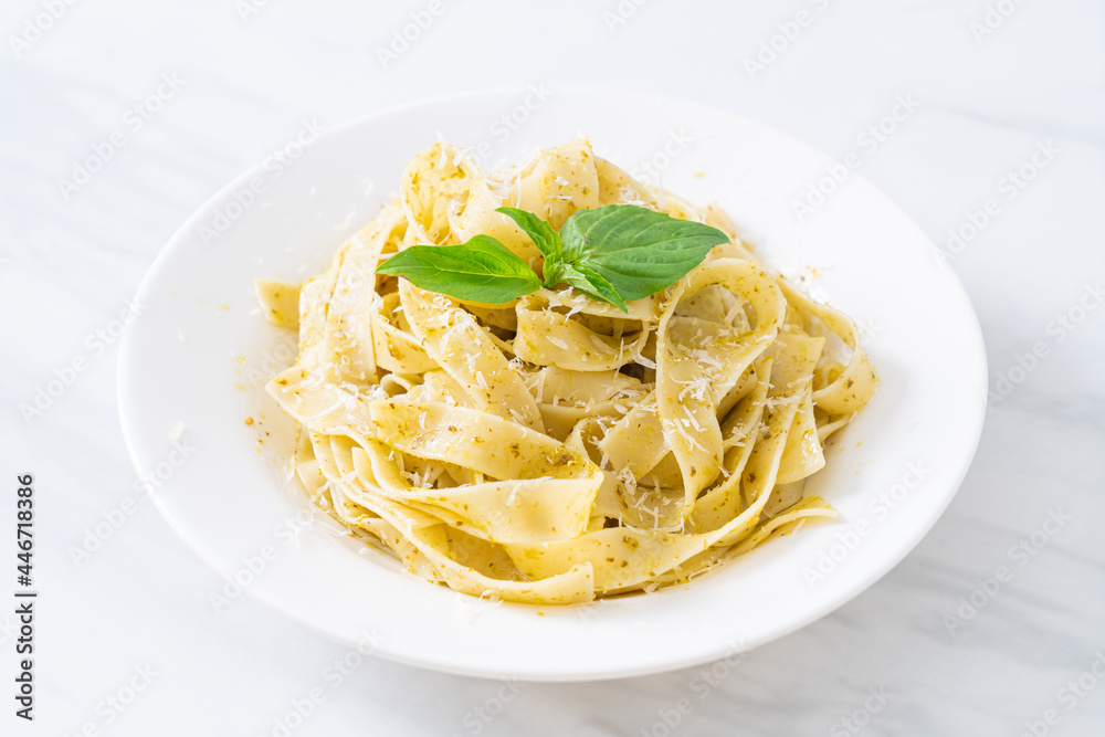 pesto fettuccine pasta with parmesan cheese on top