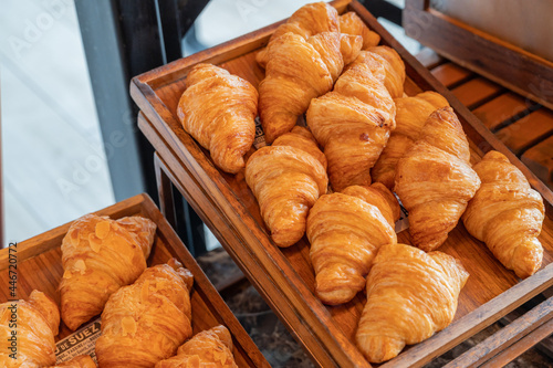 Fresh croissants in rectangle wooden tray, hotel breakfast bakery and pastry bar