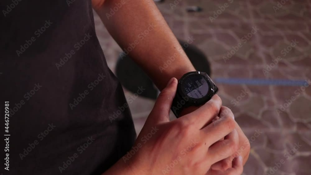 Close view of Athletic Young woman using a smartwatch. Closeup of a female touching touch screen on a smartwatch. Preparing for Crossfit exercise at home. Close view of Athletic Young woman using a smartwatch. Closeup of a female touching touch screen on a smartwatch. Preparing for Crossfit exercise at home.