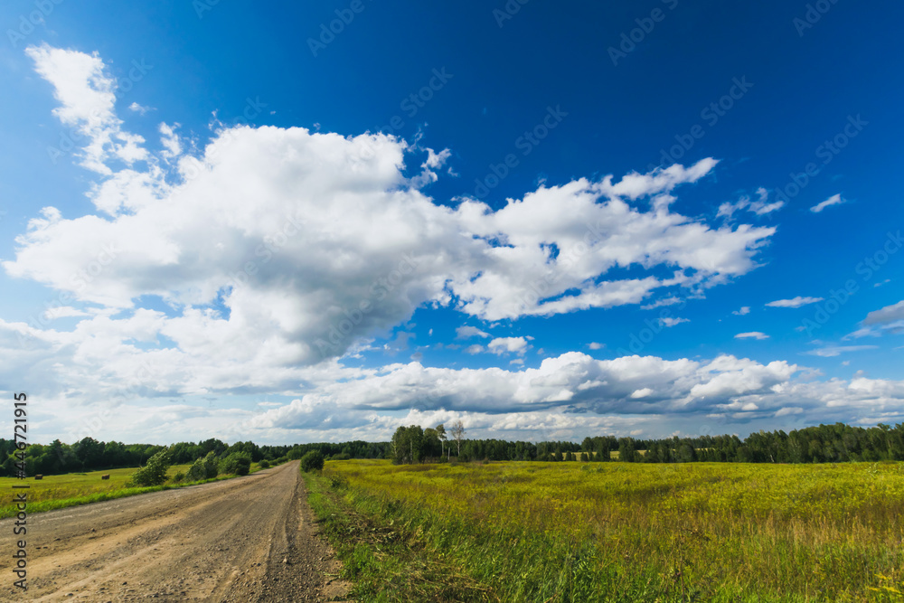 Summer countryside nature landscape. Blue sky white clouds green meadows rural road. Horizontal frame Summer countryside nature landscape. Blue sky white clouds green meadows rural road. Horizontal frame