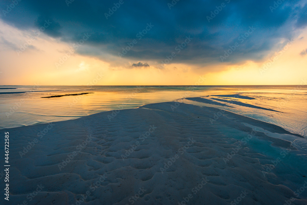 Sunset on a cloudy evening on tropical Maldivian island during low tide