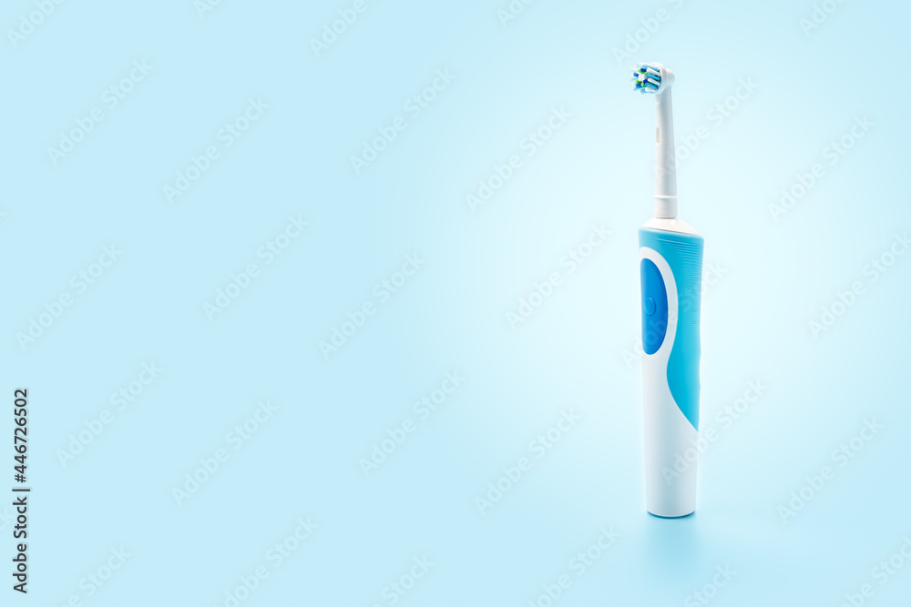 Electric Toothbrush stands upright on blue background. Modern technology for health. Healthy teeth. Dentistry. Dental care. copy space Electric Toothbrush stands upright on blue background. Modern technology for health. Healthy teeth. Dentistry. Dental care. copy space