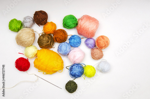 threads, multicolored skeins of thread and a needle scattered on a white background, threads for needlework.