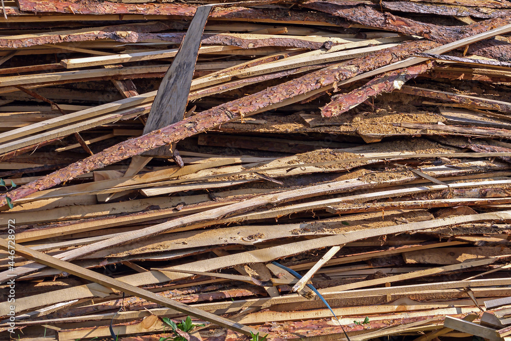 Uncut wooden boards are piled up near a rural residential building Uncut wooden boards are piled up near a rural residential building