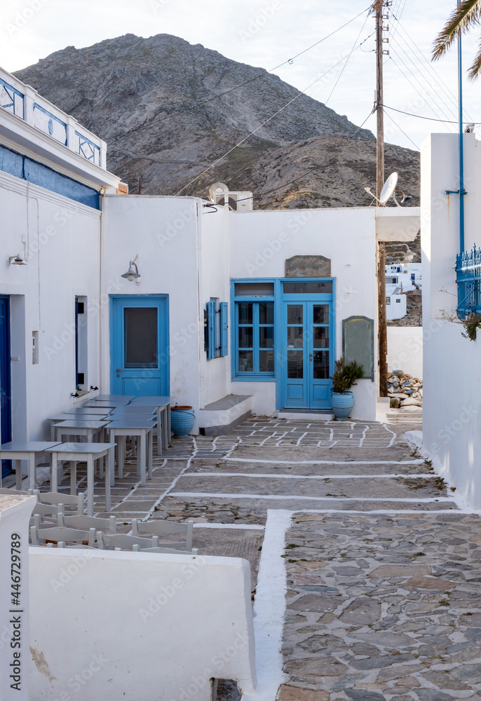 Serifos island, Chora, Cyclades Greece. Open empty cafe tavern chairs tables background.