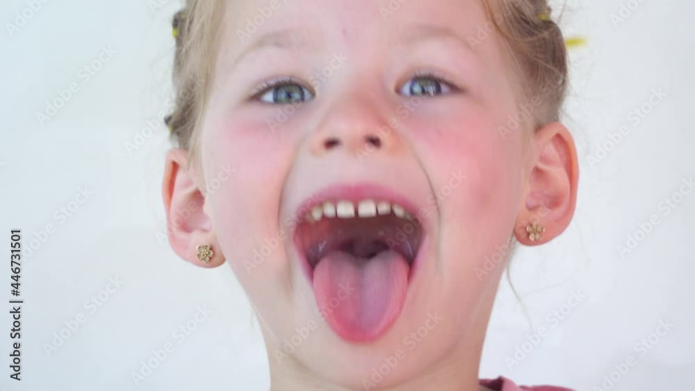 little girl show tongue, throat. portrait with wide open mouth and protruding tongue. with clear view pulls out long tongue. soft palate and mouth to dentist. mouth is wide open, tongue is stuck out. ▶0:19      
