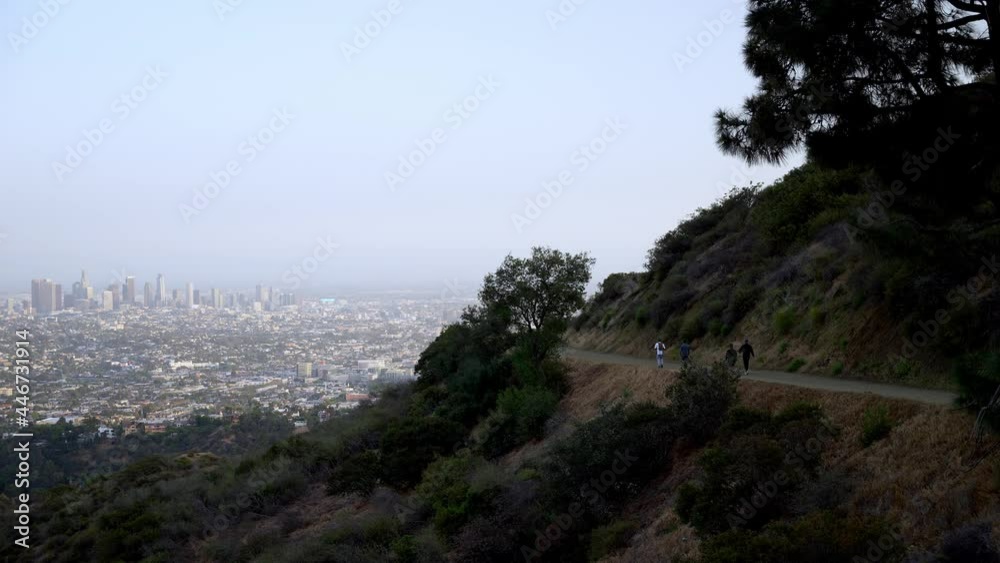 View of Los Angeles downtown and people hiking on the hills