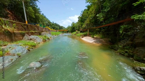 Racing drone flying under bridge on Jimenoa river at Jarabacoa, Dominican Republic. Aerial fpv photo