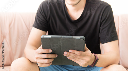 man using digital tablet while relaxing on sofa. Concept of young business people working at home