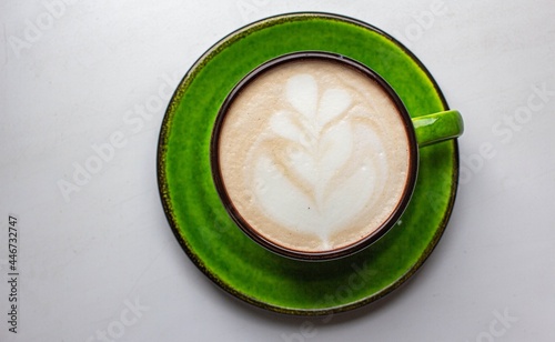 latte in nice green cup with latte art. morning coffee 