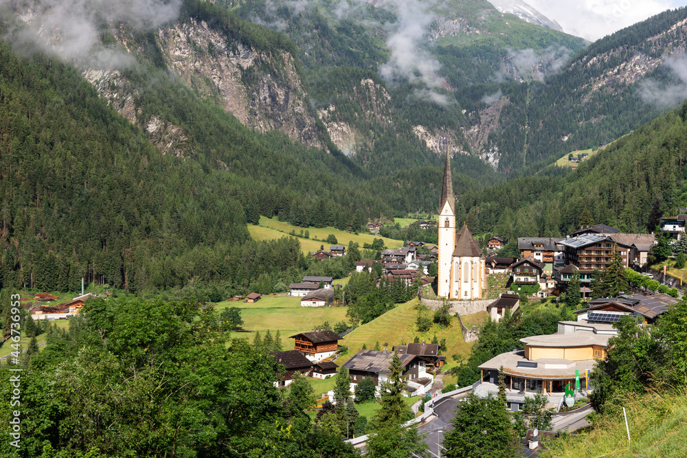 Fototapeta premium Heiligenblut with St. Vincent Church in front of the Hohe Tauern mountains. Carinthia. Austria